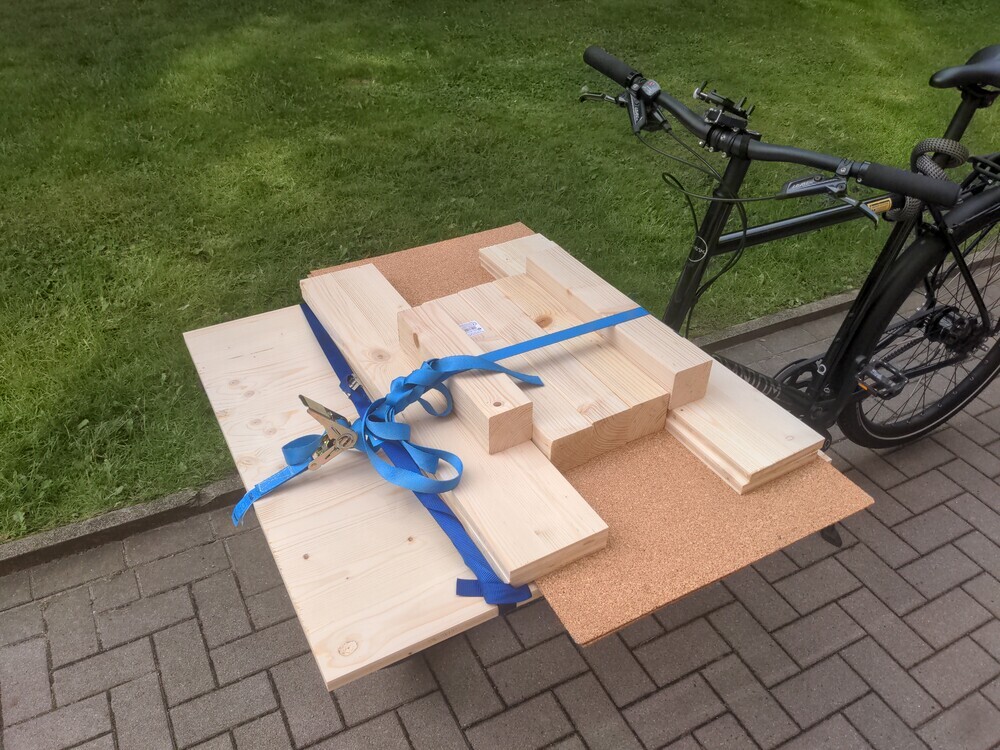 a big woodpanel and some smaller things, and big cork sheets on a cargo bike.